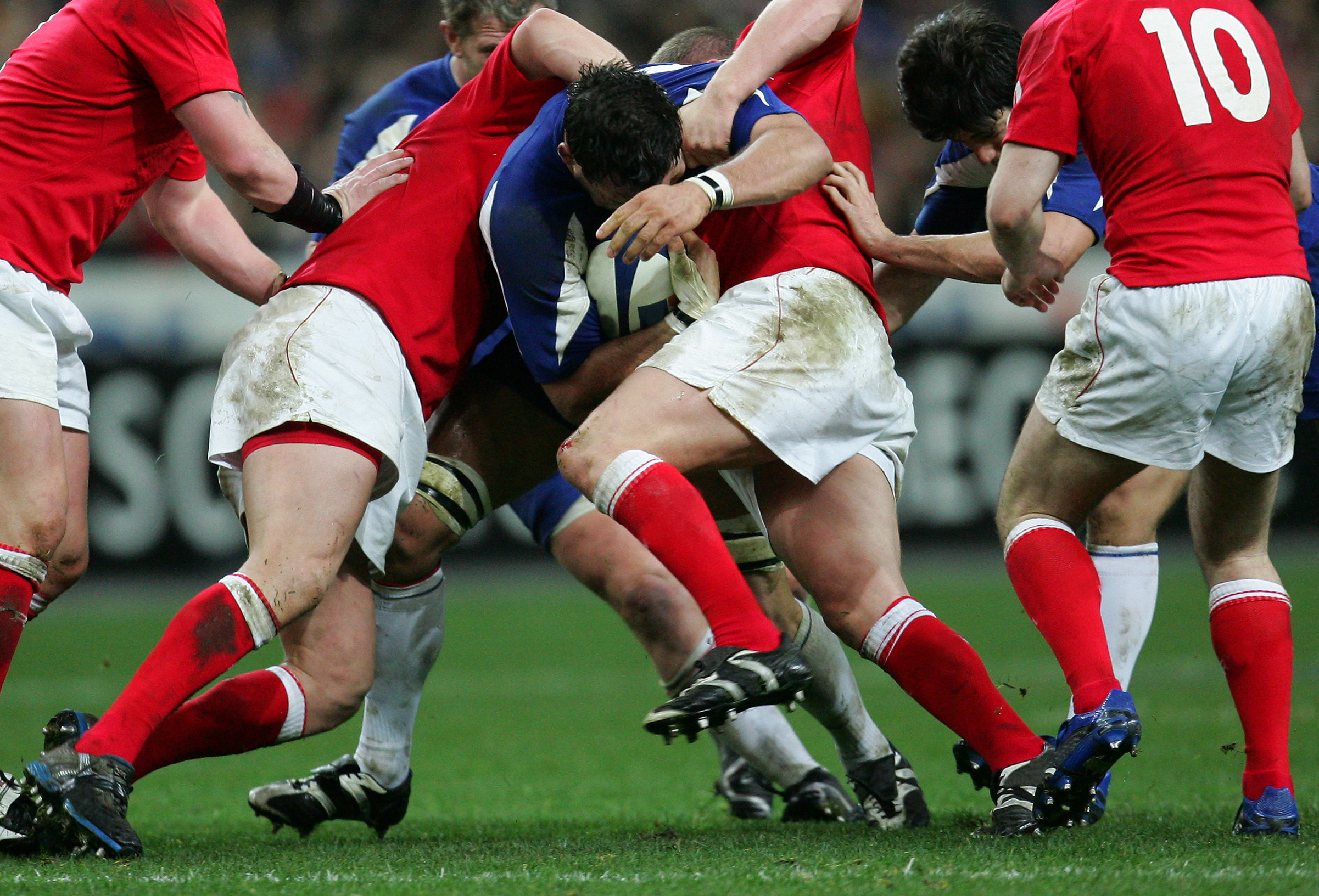 Red team and blue team playing rugby match.